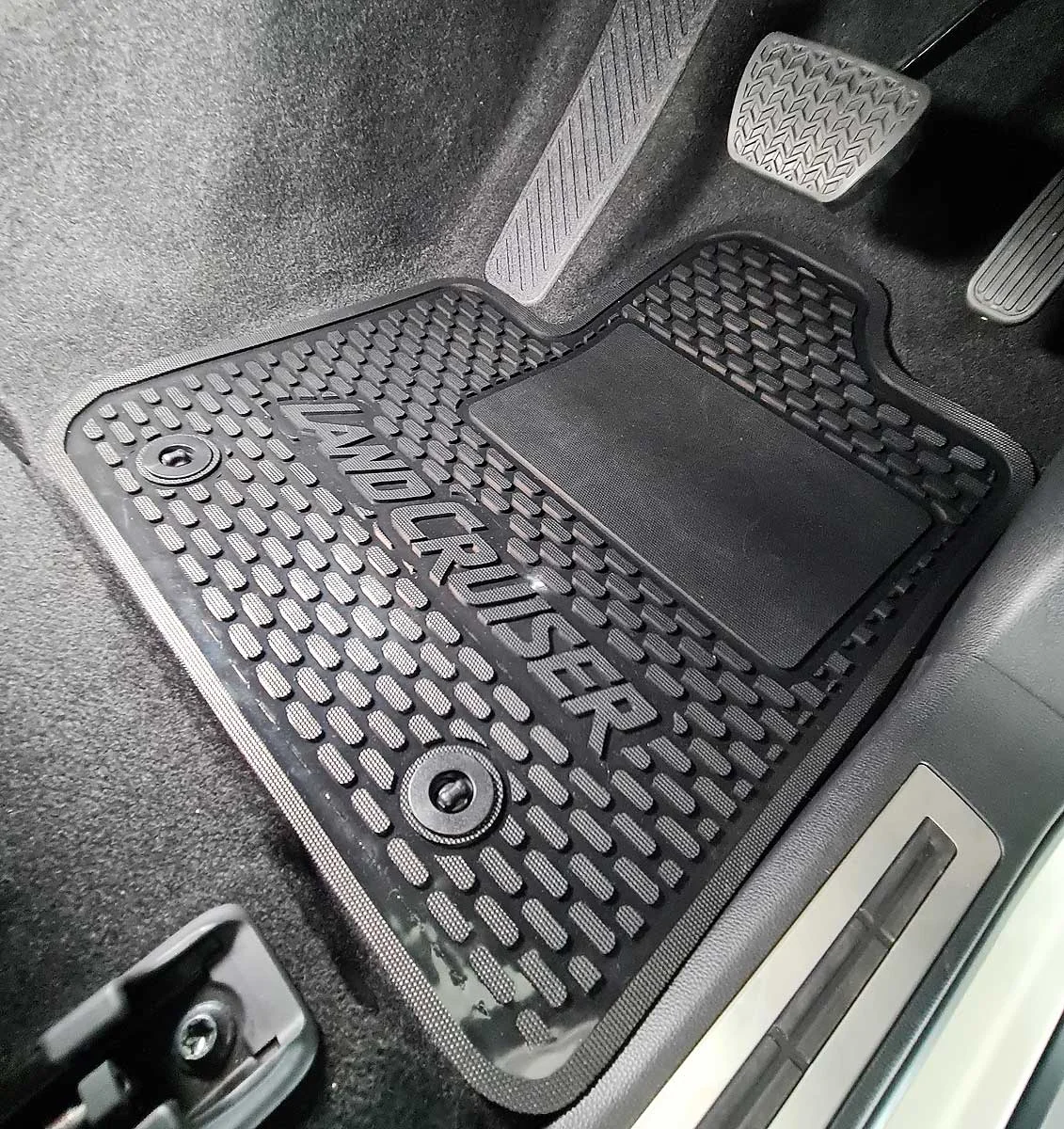 Custom-fit rubber car floor mats installed in a vehicle footwell